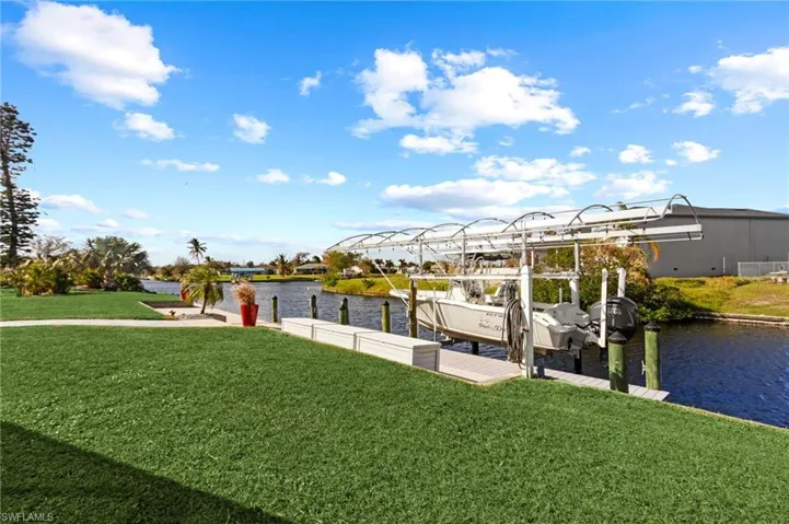 Dock area featuring a water view and a lawn