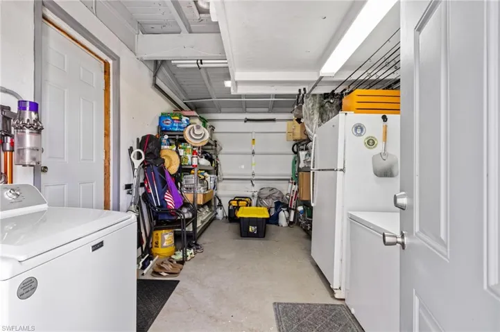Garage featuring washer / dryer and white fridge