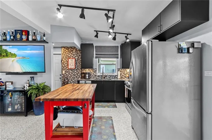 Kitchen featuring lofted ceiling, sink, appliances with stainless steel finishes, and backsplash