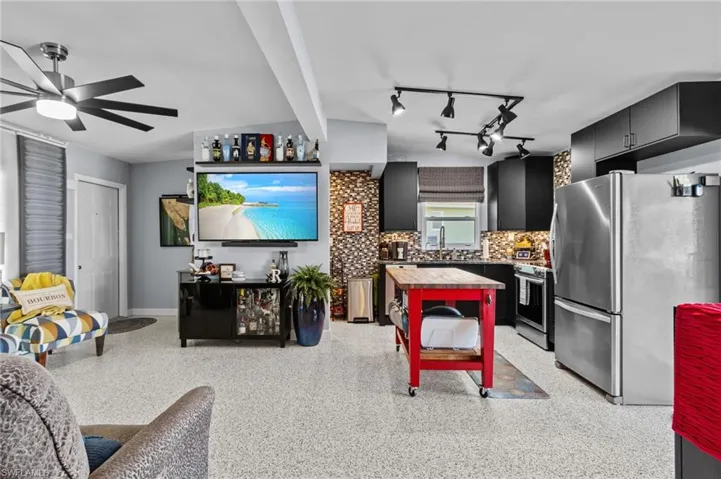 Kitchen with backsplash, wood counters, sink, appliances with stainless steel finishes, and ceiling fan