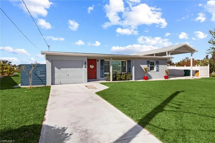 Ranch-style home with a garage and a front lawn