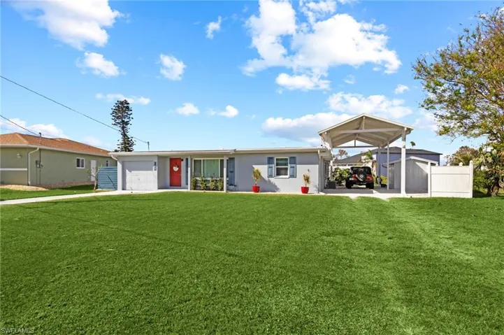 View of front of home featuring a front lawn and a carport