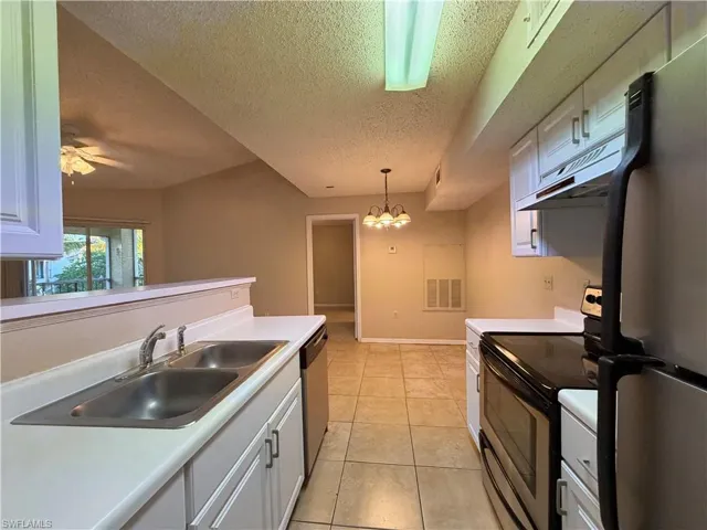 Kitchen featuring stainless steel appliances, a textured ceiling, light countertops, ceiling fan, and white cabinetry