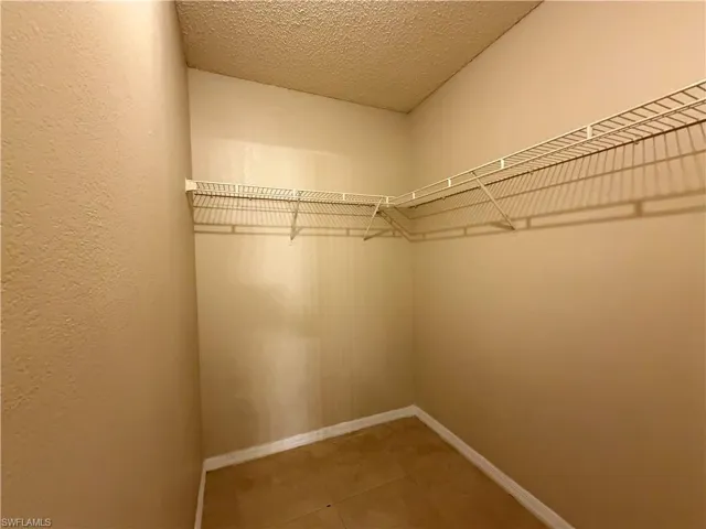 Walk in closet with light tile patterned floors