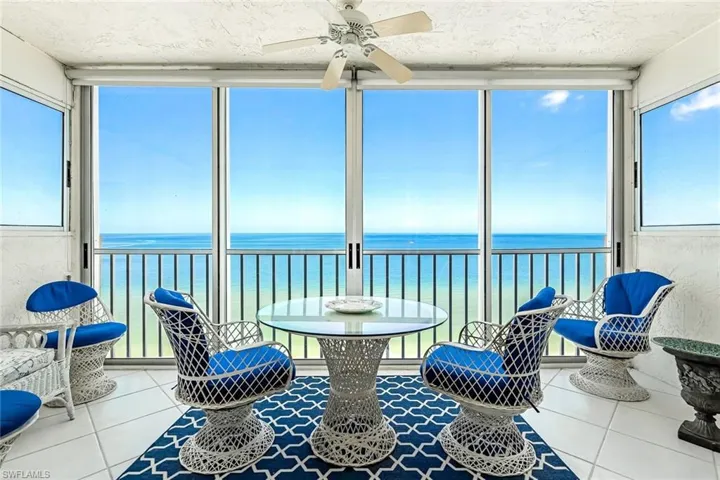 Sunroom / solarium featuring a water view and ceiling fan