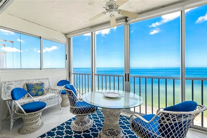 Sunroom featuring plenty of natural light, a water view, and ceiling fan