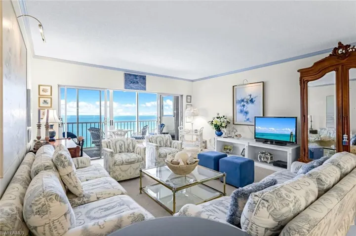Carpeted living room with a water view and ornamental molding