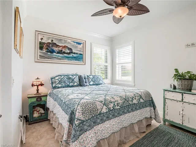 Bedroom / Den with ceiling fan, light tile floors, and crown molding