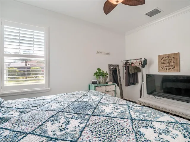 Bedroom featuring ceiling fan and crown molding