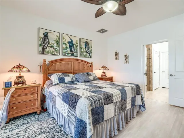 Bedroom with ceiling fan, light hardwood / wood-style floors, and ensuite bathroom