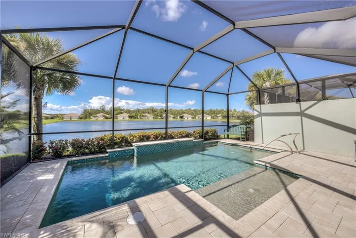 View of pool featuring a patio, a lanai, and a water view
