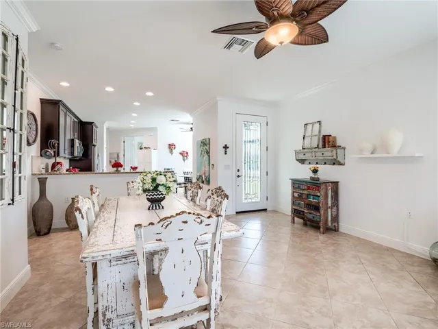 Tiled dining room featuring ornamental molding and ceiling fan