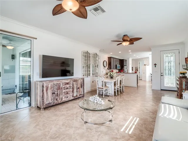Tiled living room featuring ornamental molding and ceiling fan