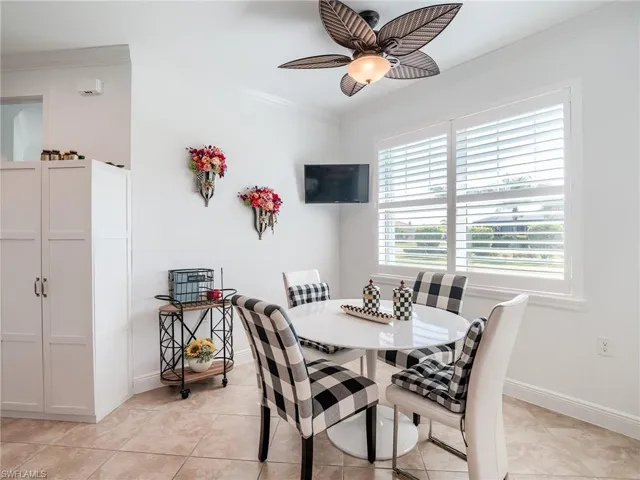 Dining area featuring ornamental molding, ceiling fan, and light tile floors