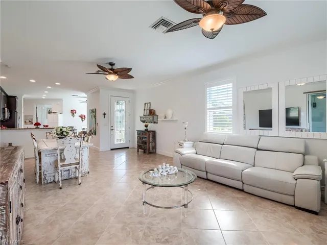 Tiled living room with ornamental molding and ceiling fan