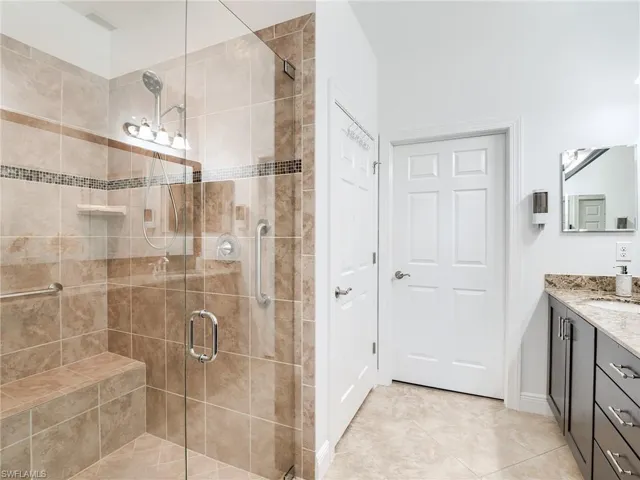 Bathroom featuring tile flooring, an enclosed shower, and vanity