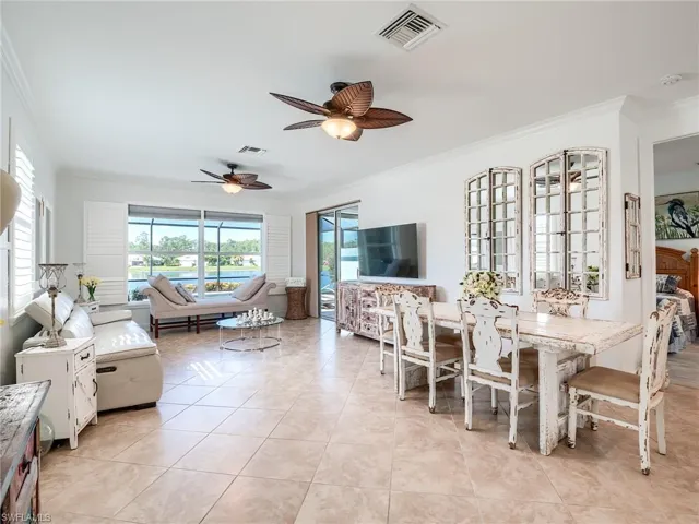 Tiled dining room featuring ornamental molding and ceiling fan