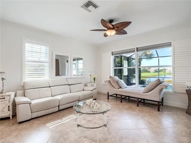 Living room with ornamental molding, ceiling fan, and light tile floors