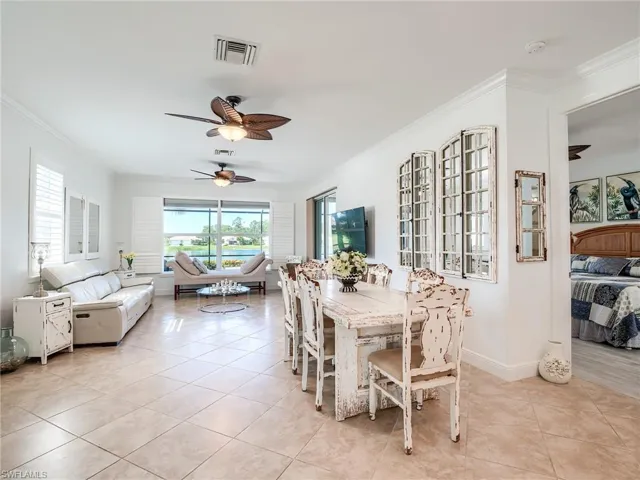 Dining area with ceiling fan, light tile floors, and ornamental molding