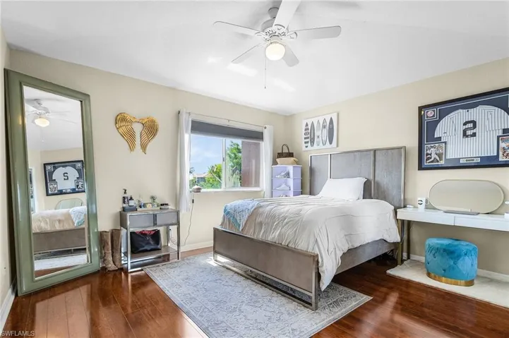 Bedroom with wood finished floors, baseboards, and ceiling fan