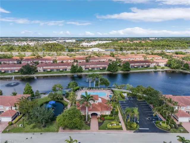 Aerial perspective of suburban area featuring a nearby body of water and a pool area