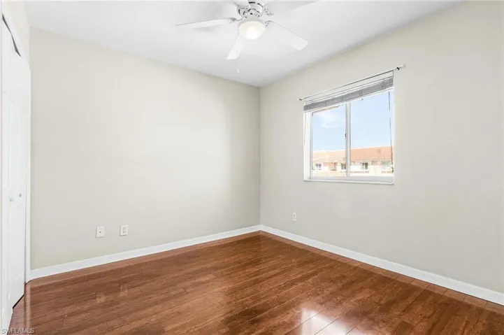 Empty room with wood finished floors, baseboards, and ceiling fan