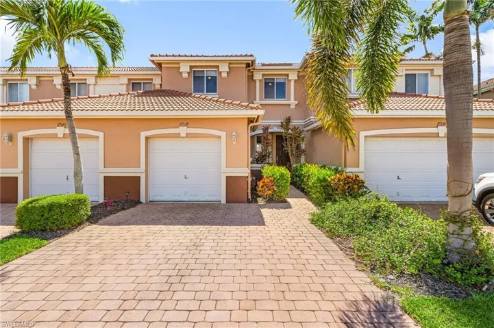 View of front of home with stucco siding, a tile roof, and decorative driveway