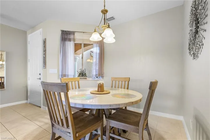 Dining room featuring a chandelier, light tile patterned floors, and baseboards