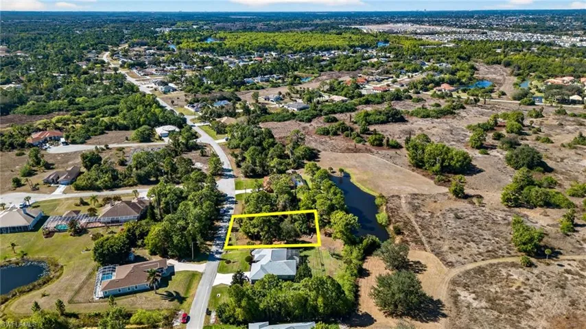 View of property location with property parcel outlined, a large body of water, and nearby suburban area