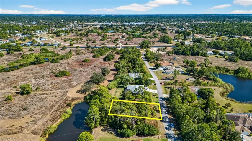 Aerial view of residential area featuring a large body of water and property boundaries highlighted