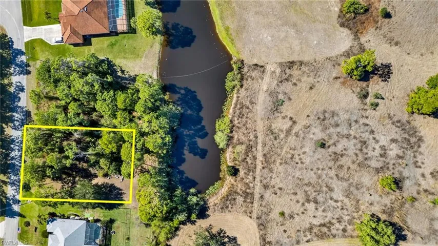 Aerial view of property's location featuring a nearby body of water and property parcel outlined