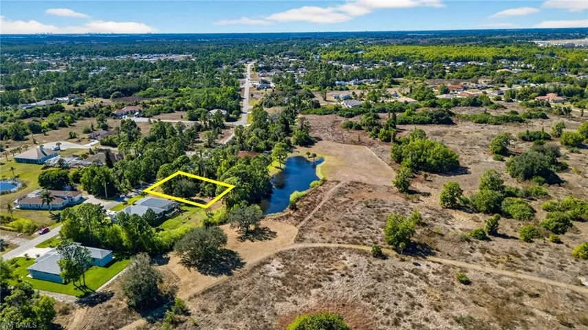 Aerial view of property and surrounding area with a large body of water and property parcel outlined