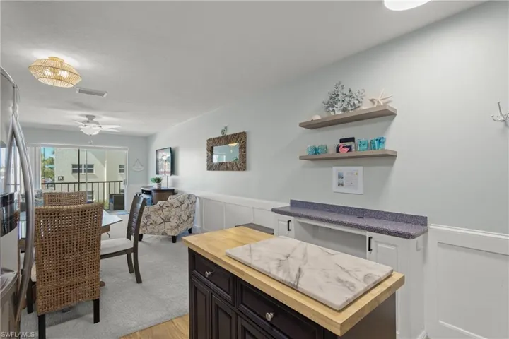 Kitchen featuring wooden counters, ceiling fan, white cabinets, light wood-style floors, and freestanding refrigerator