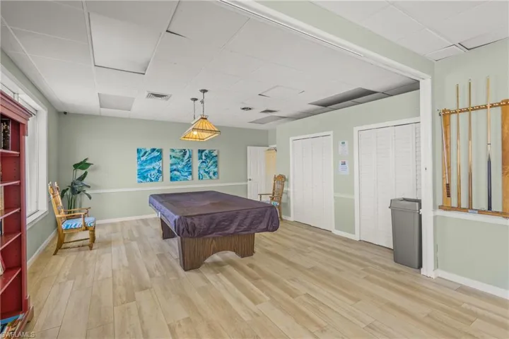 Rec room with billiards table, a paneled ceiling, and light wood-type flooring