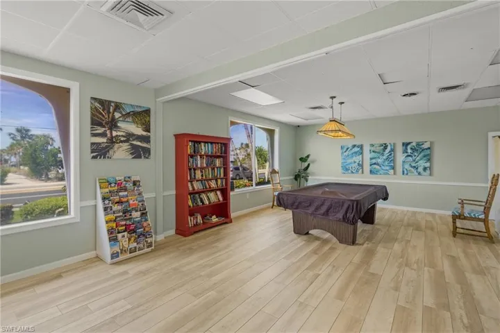 Game room with a paneled ceiling, billiards table, and light wood finished floors
