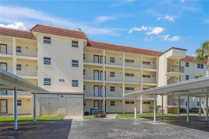View of apartment building / complex with covered parking