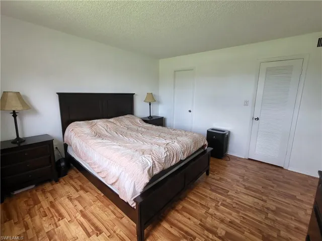 Bedroom 1 featuring wood-type flooring and a textured ceiling