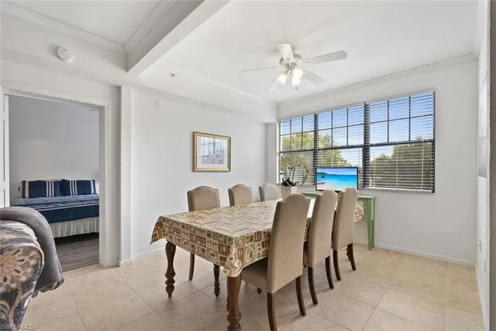 Dining space featuring crown molding, light tile patterned floors, and a ceiling fan