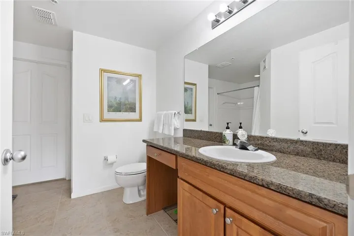 Bathroom featuring vanity, light tile patterned floors, and a shower with curtain