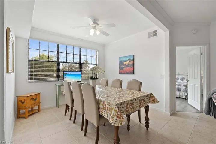 Dining area featuring crown molding, light tile patterned floors, and ceiling fan