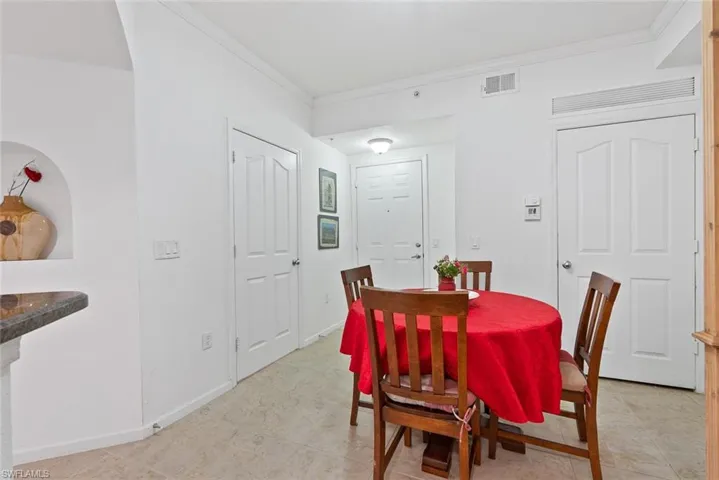 Dining room featuring ornamental molding and light tile patterned floors