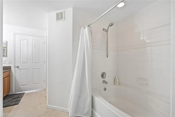 Full bathroom featuring shower / tub combo, vanity, and light tile patterned floors