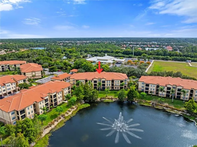 Drone / aerial view of apartment complex and a large body of water