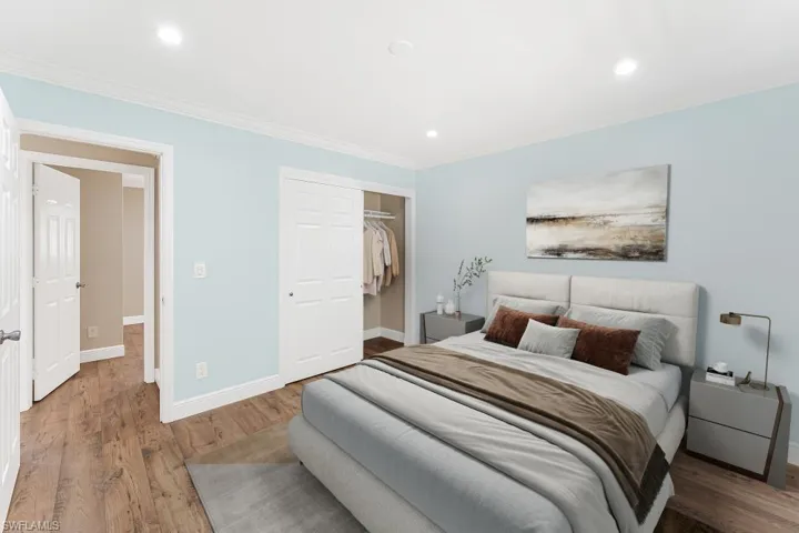 Bedroom featuring ornamental molding, light wood-style flooring, a closet, and recessed lighting