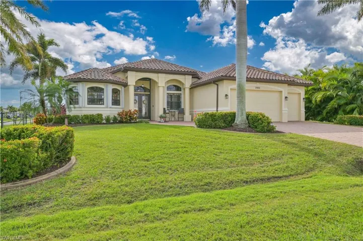 Mediterranean / spanish home featuring a garage and a front lawn