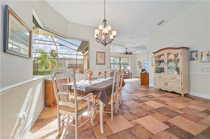 Dining space with beam ceiling, ceiling fan with notable chandelier, and coffered ceiling