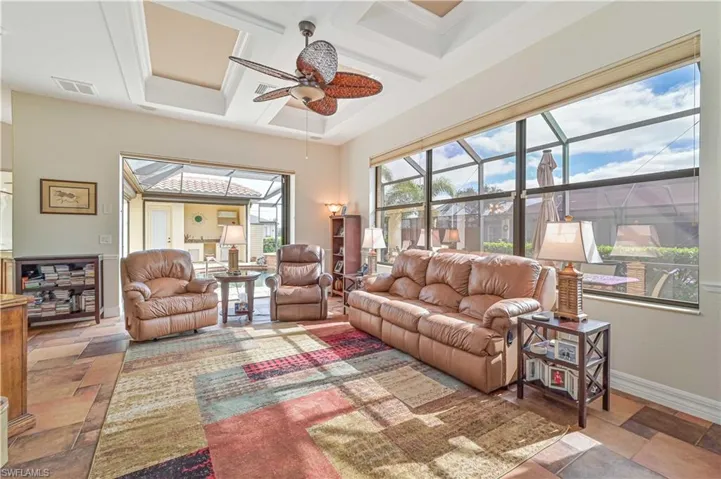 Living room featuring ceiling fan, beam ceiling, and coffered ceiling
