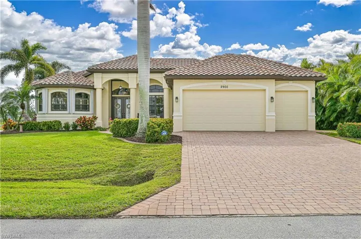 Mediterranean / spanish-style house with a garage and a front lawn