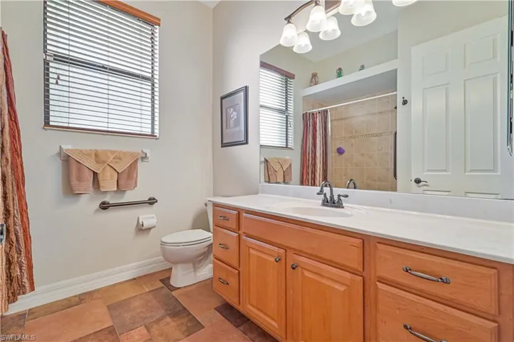 Bathroom with curtained shower, vanity, and toilet