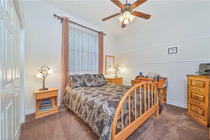 Bedroom featuring dark colored carpet, a closet, and ceiling fan